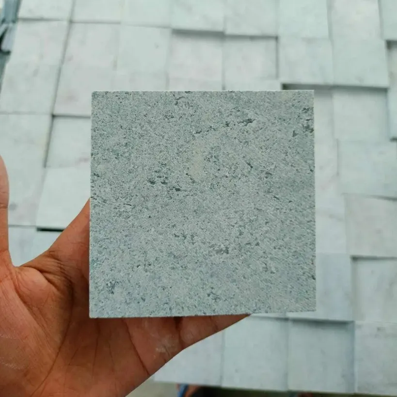 Tiles — Sukabumi Green Stone tile sample in natural cleft finish held up for close inspection